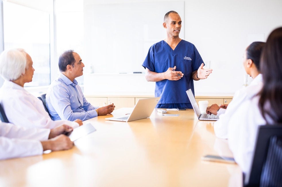 Presenter speaking in clinical meeting.