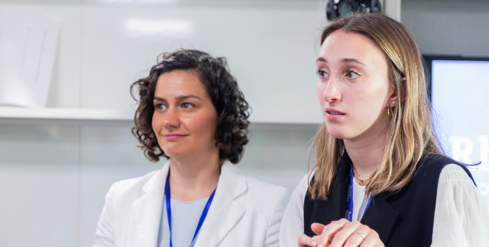Two Boston Scientific employees sitting at the table watching a seminar