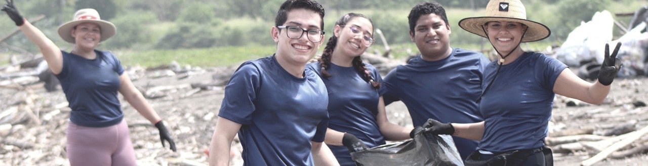 Funcionário vestindo uma camiseta da Boston Scientific em um ambiente ao ar livre sorri para a câmera.