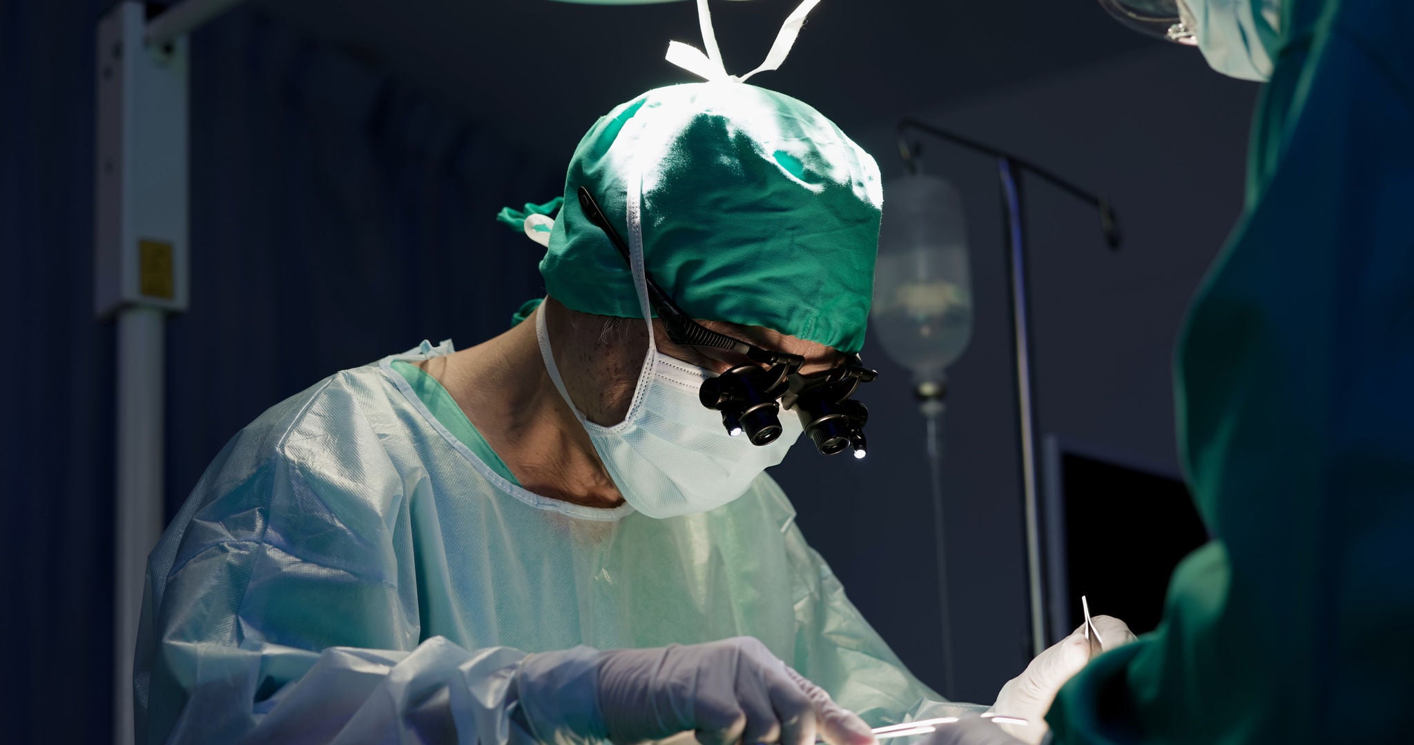Surgeon performing neurological surgery procedure in operating room.