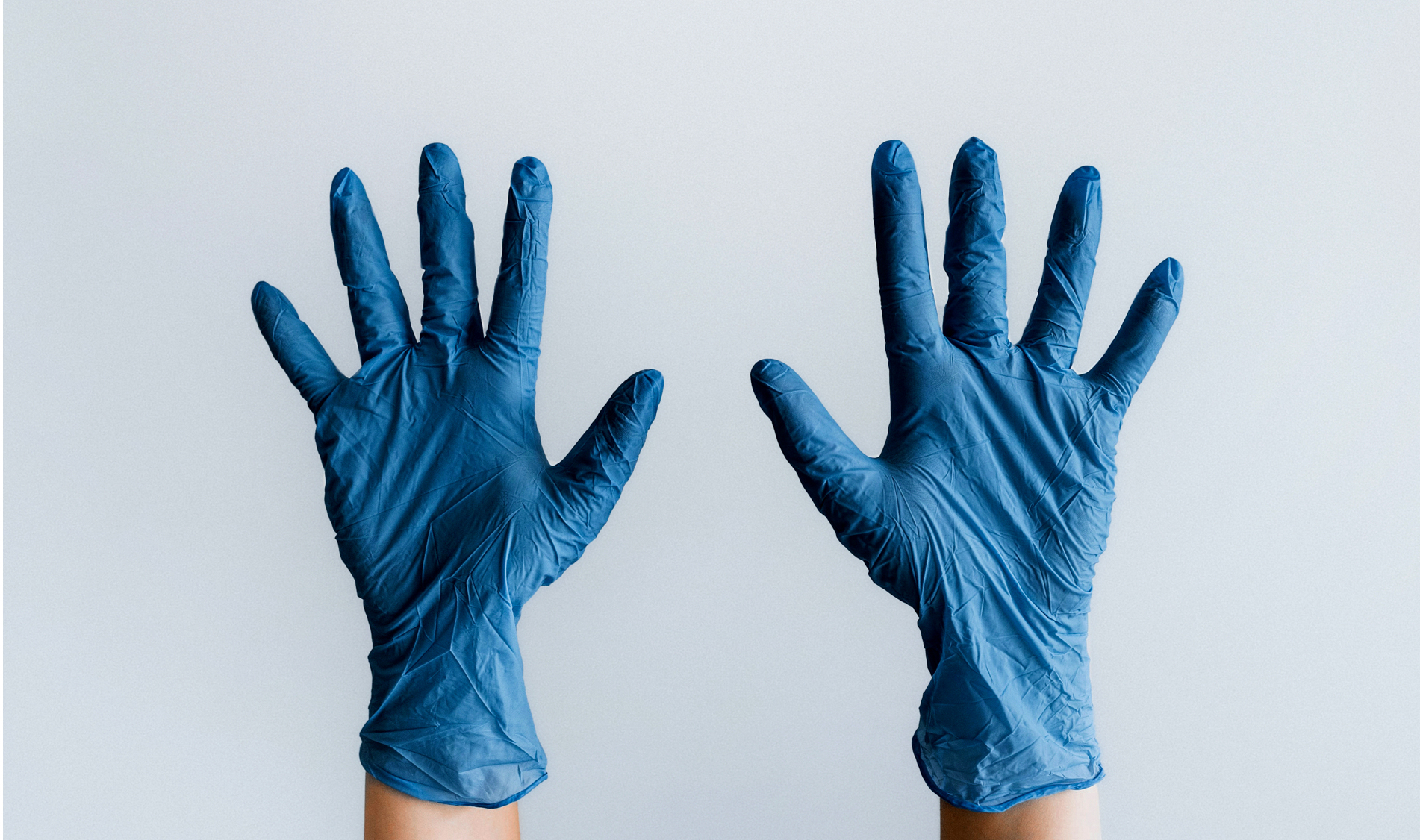 Two hands pointing upward, wearing blue latex gloves