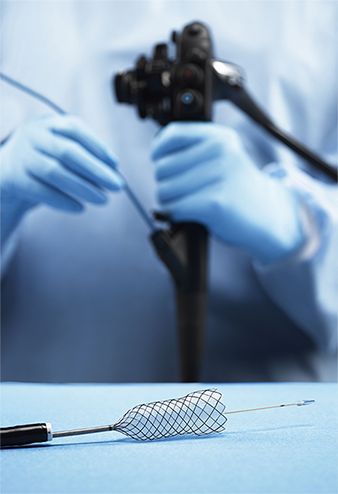Gloved physician feeding Agile stent system into scope.