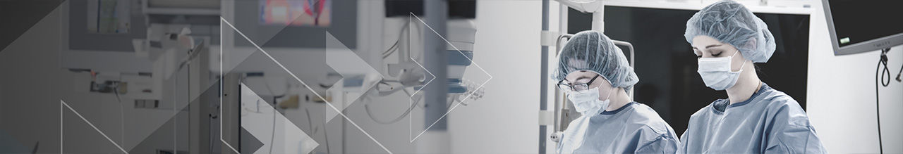 two women with face mask in lab coat with head cap.