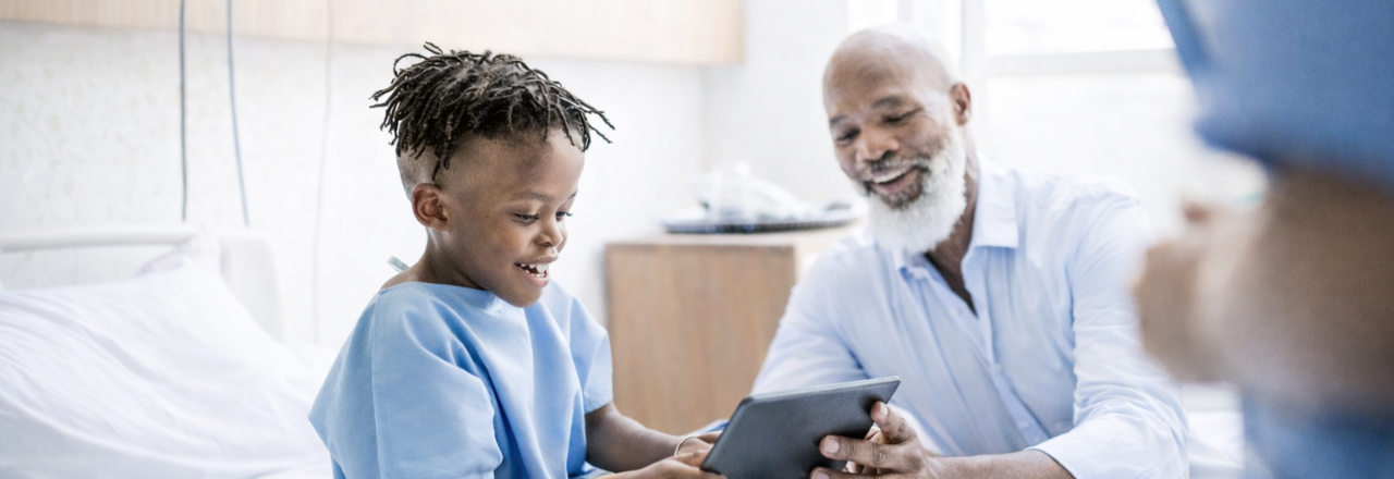 A man in mask sitting with young girl and giving instruction.