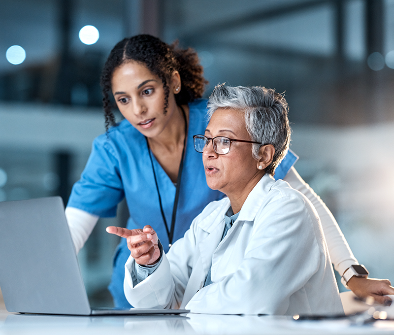 Banner that shows two physicians looking at data on a laptop. 