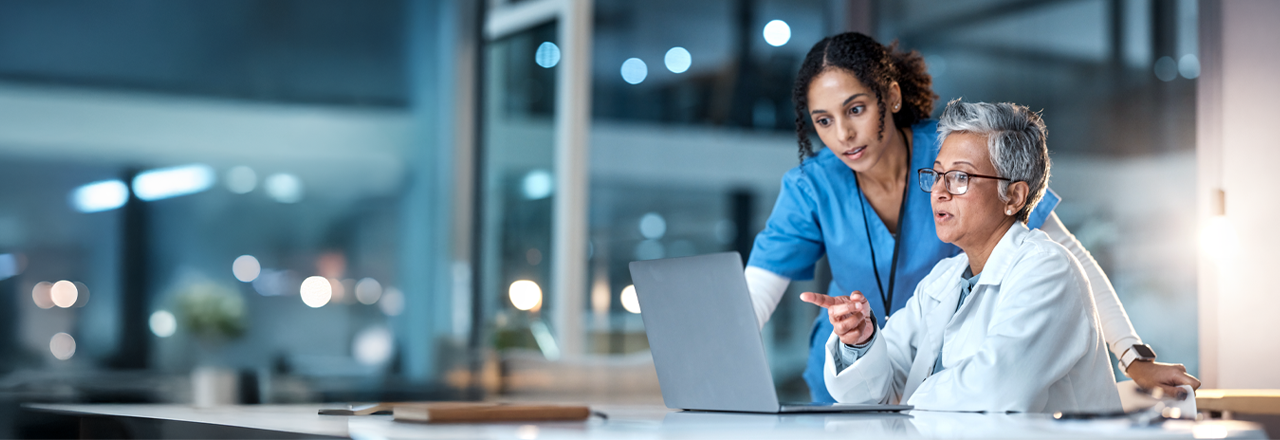 Banner that shows two physicians looking at data on a laptop. 