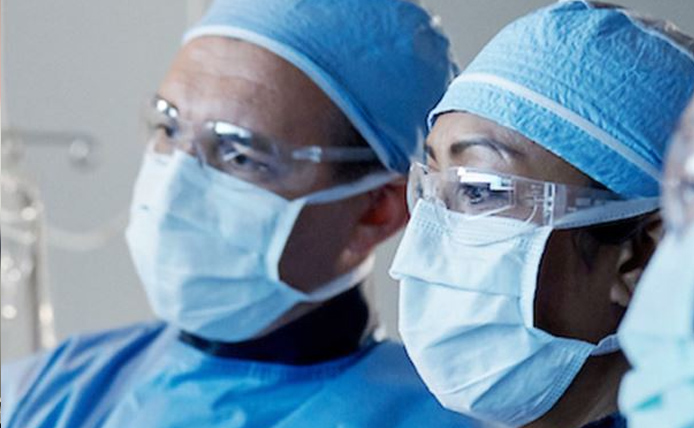 Men holding and checking a medical device