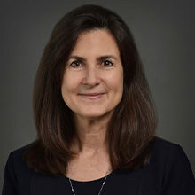 Headshot of Cindy R. Smith in black coat and smiling face.