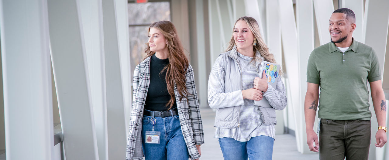 Coworkers walking together in modern corridor.