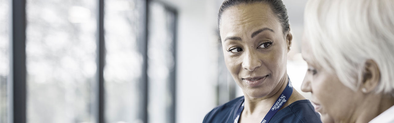 Two women talking and looking toward each other.