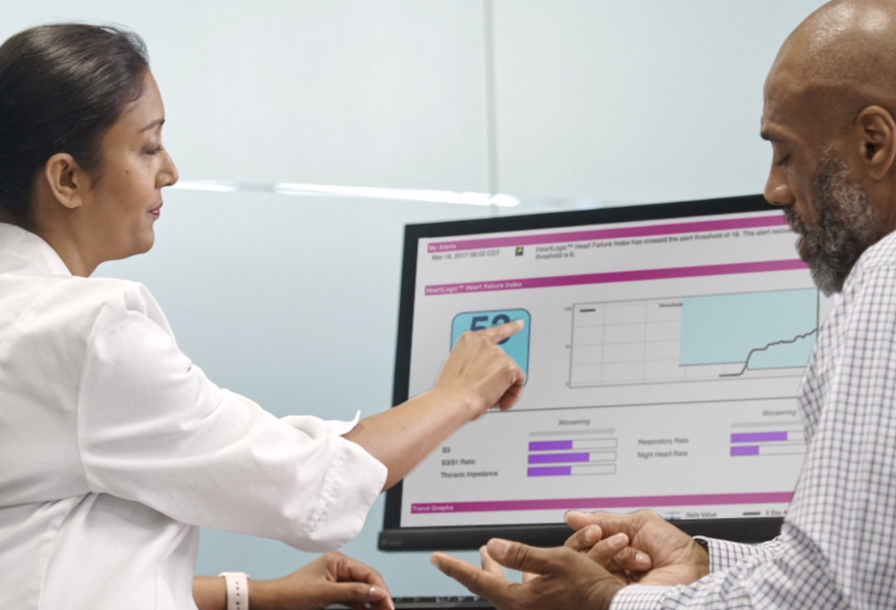 Healthcare professional showing a patient the HeartLogic Heart Failure Diagnostic on a computer screen.