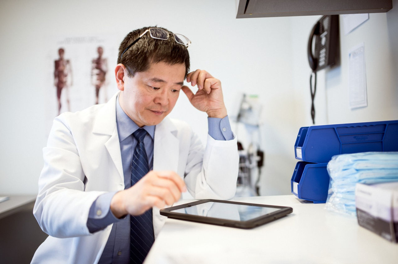 Healthcare provider working at tablet.