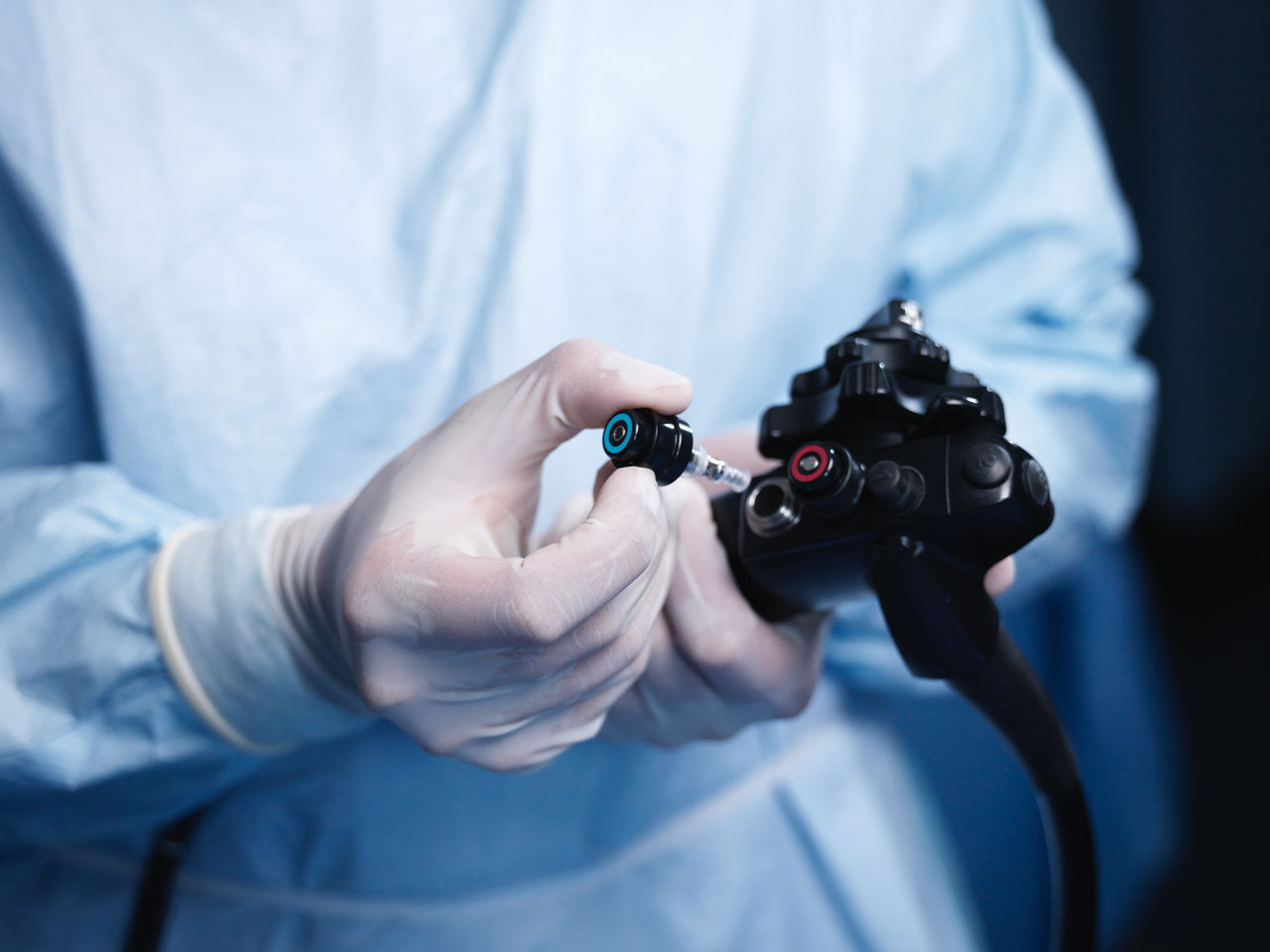 Gloved hands operating medical device.