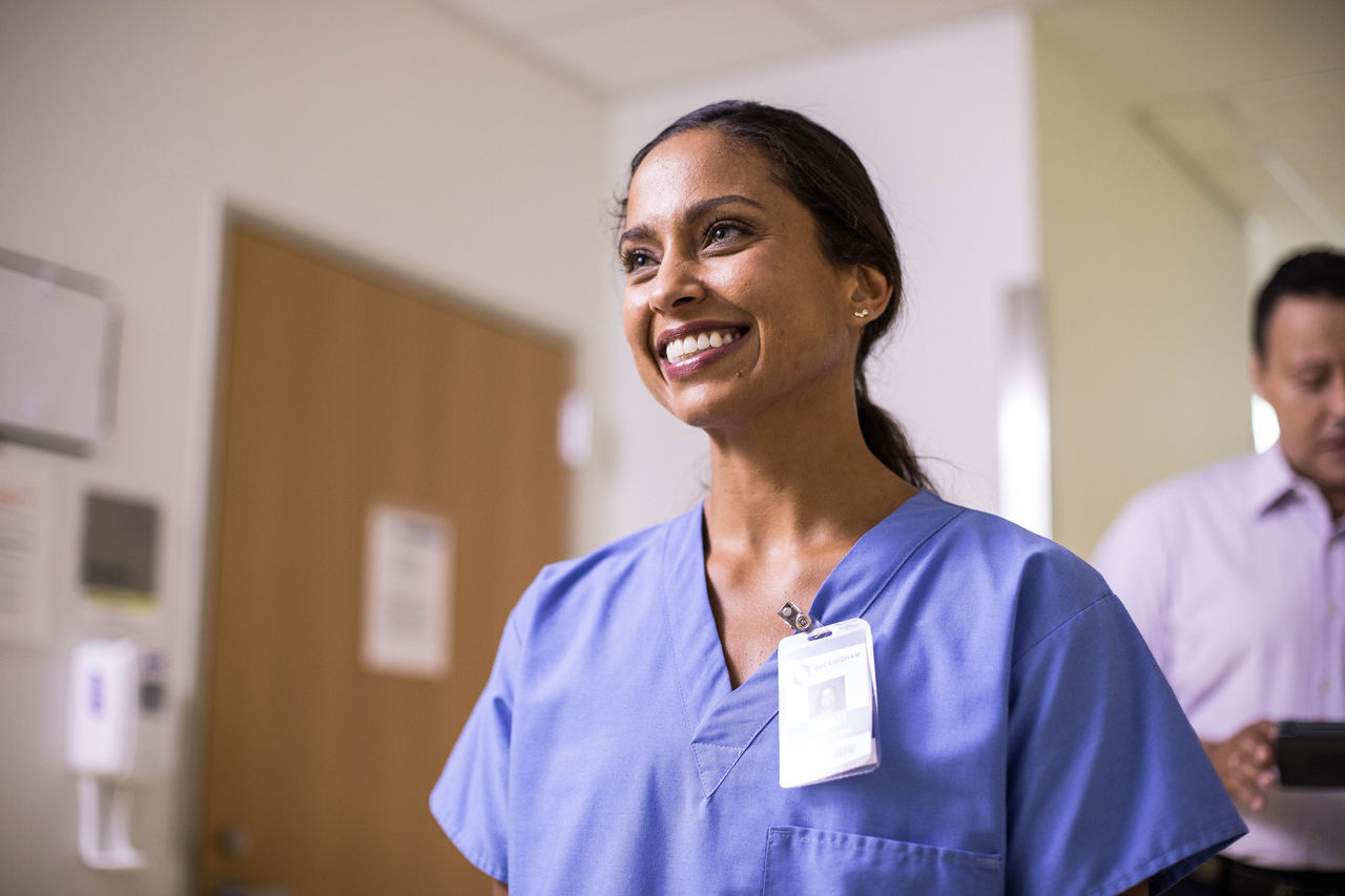 Nurse wearing scrubs and smiling.
