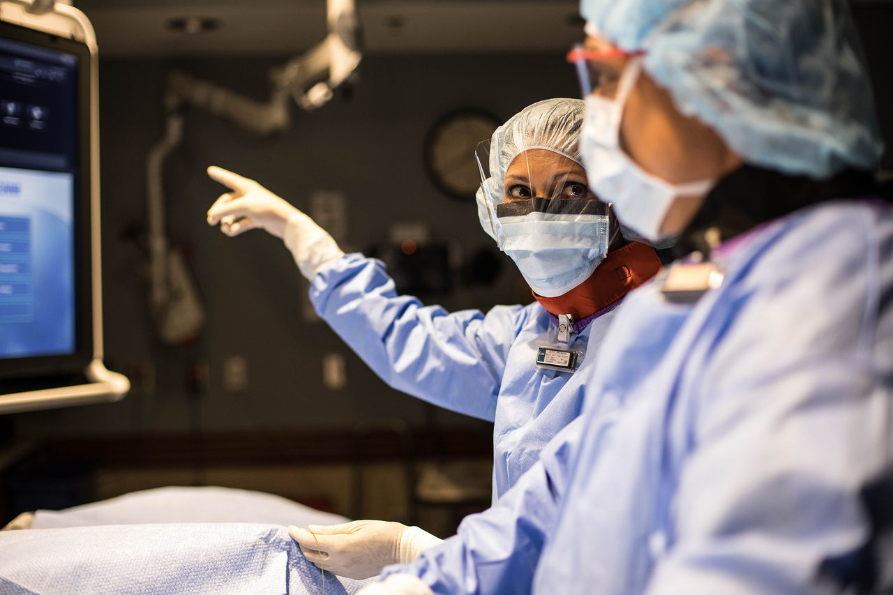 Healthcare provider pointing to screen in clinic.