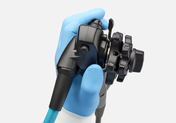 A healthcare worker wearing surgical gloves and gown handles the EXALT Model D Single-Use Duodenoscope