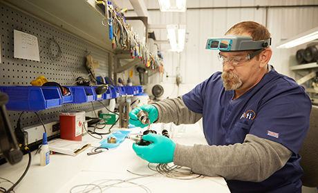 Man working on scope repair in a lab.