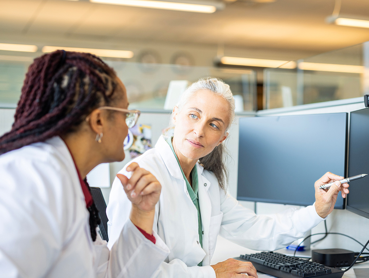Two physicians talking in front of a computer.