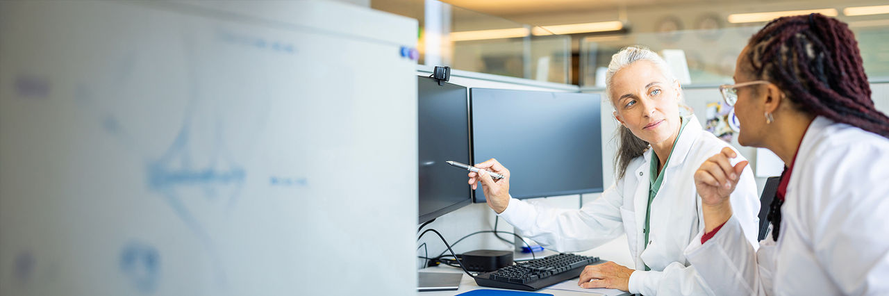 Two female healthcare workers looking at a monitor.