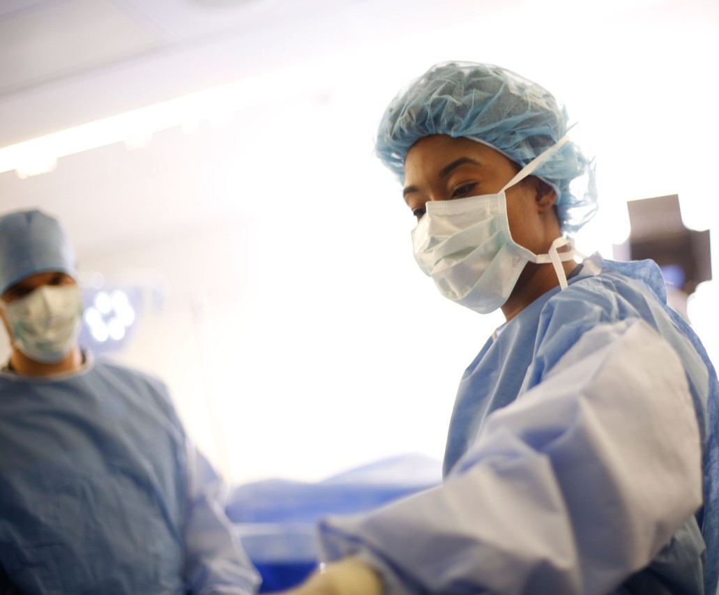 Female physician selecting tools during surgery procedure. 