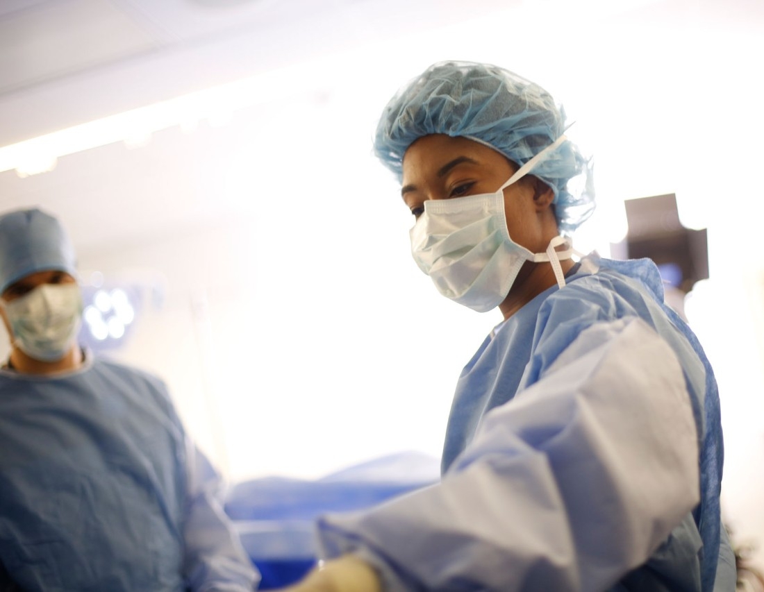 Female physician selecting tools during surgery procedure. 