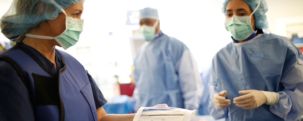 Multiple physicians discussing process during surgery.