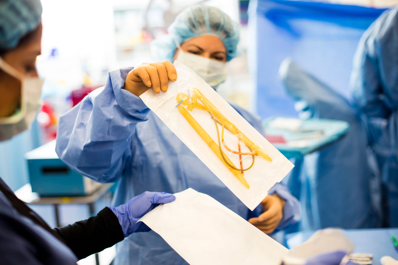 doctors holding up AMS 700 in packaging in the operating room