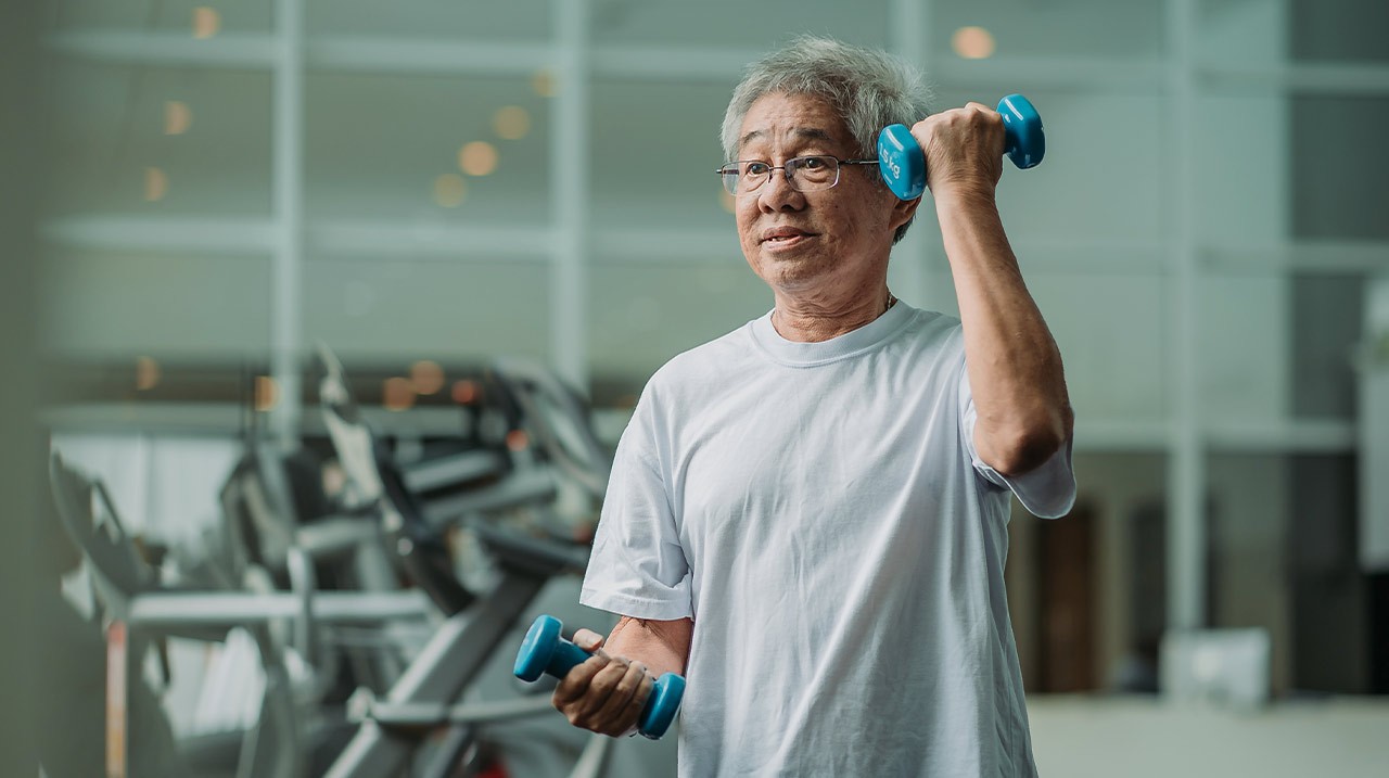 Older man lifting weights in gym