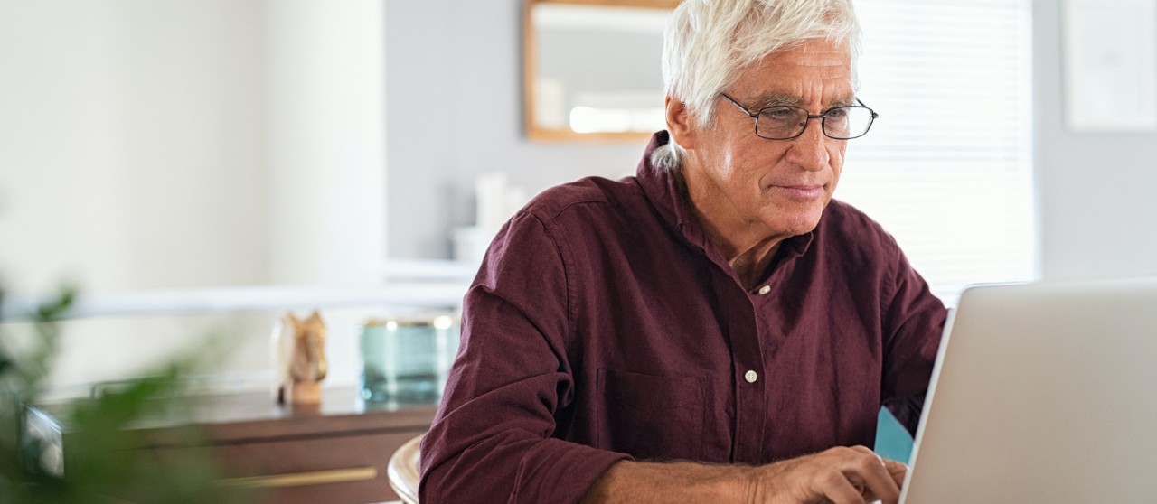 Older man browsing through laptop