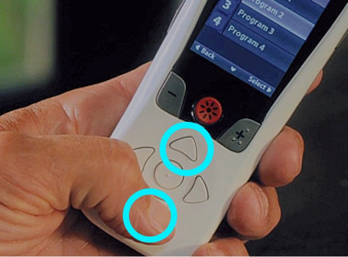 Person holding remote with the up and down arrows highlighted