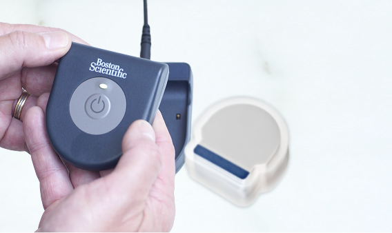 Hands holding SCS charging system with patches.