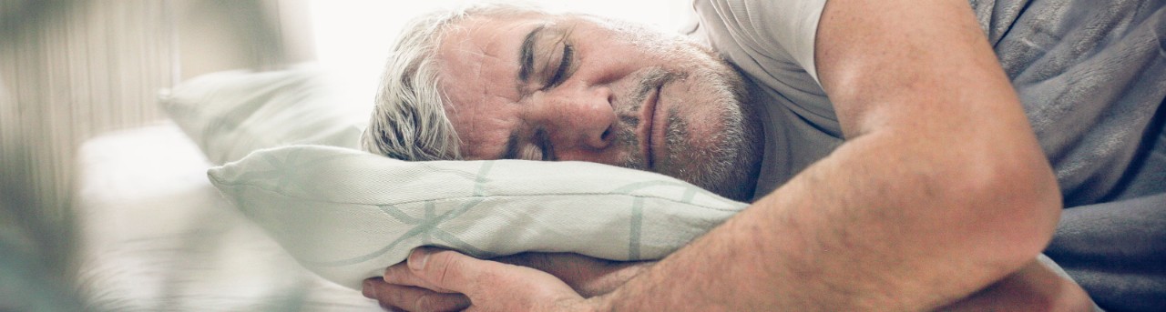 Middle-aged man sleeping on his side.