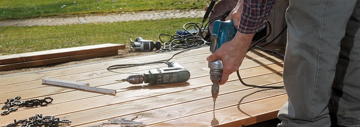Background image with a man using a drill