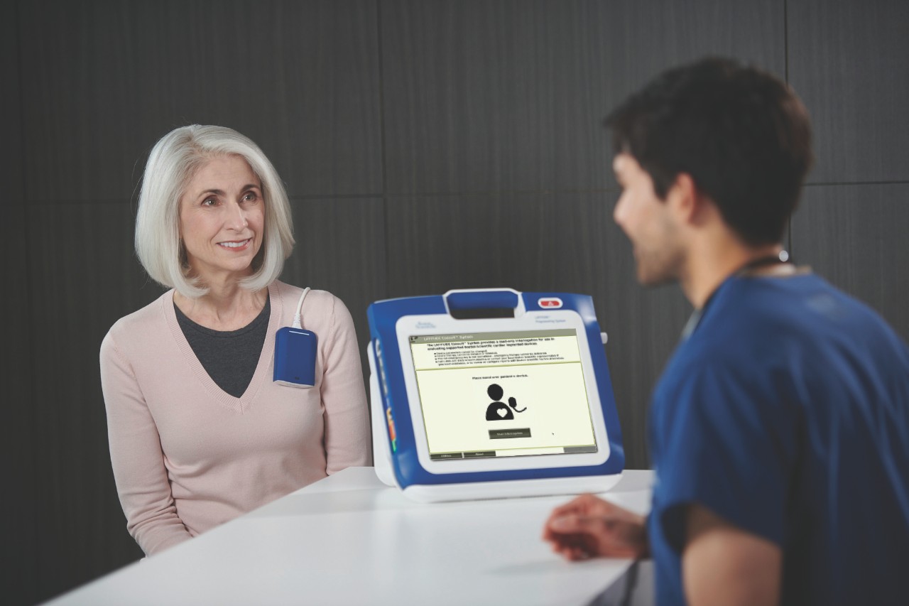 A clinician conducting a device check on a patient using LATITUDE Consult.