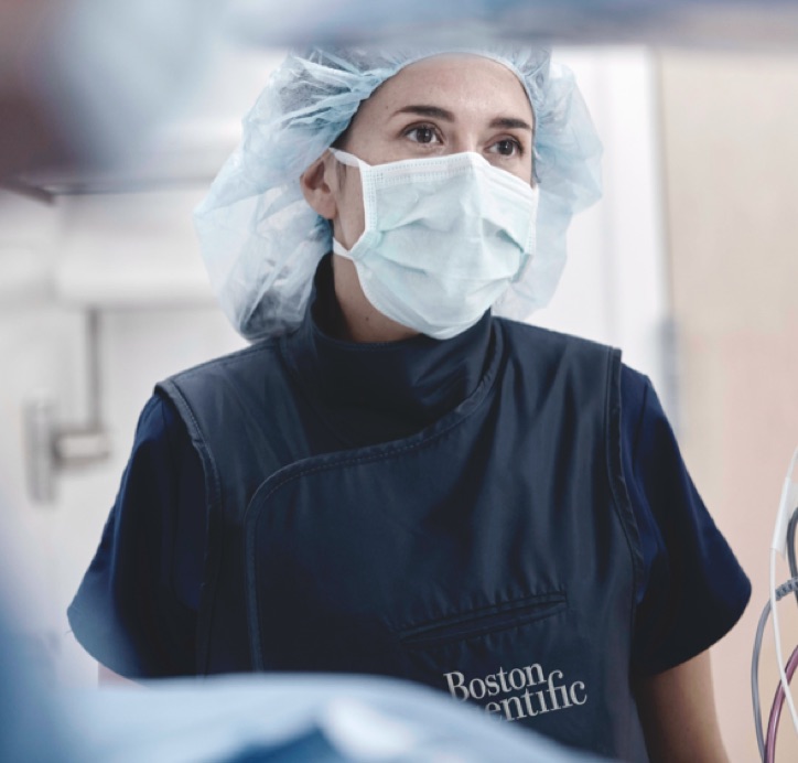 Person in surgical cap and mask with Boston Scientific logo underneath pocket.