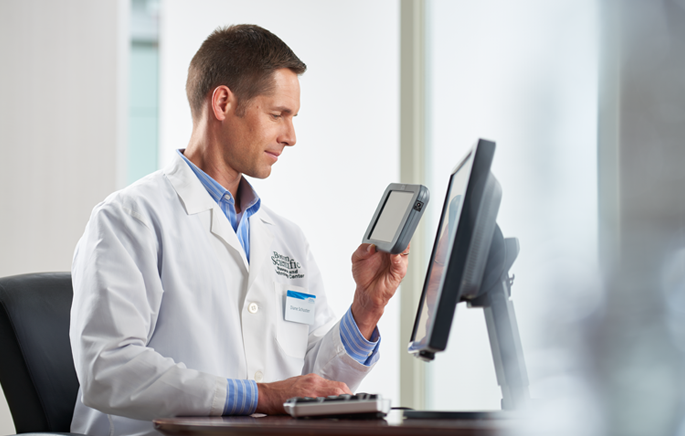 A clinician conducting a device check on a patient using LATITUDE Consult.