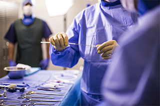 Physician Holding Needle