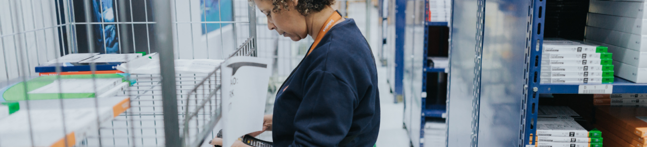 Mulher de cabelos escuros fazendo controle no centro de distribuição