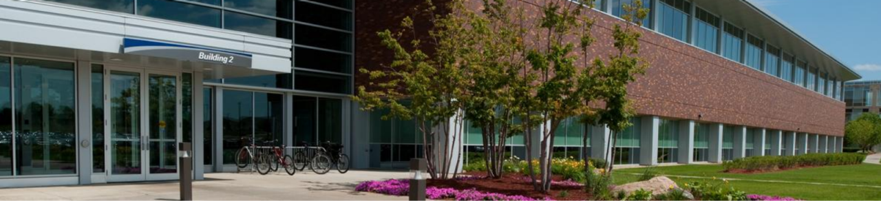 Prédio da Boston Scientific em Maple Grove, MN. Com várias árvores, portas e grama.